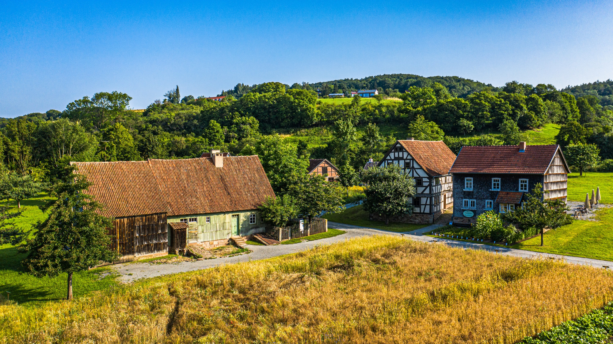 Luftbildaufnahme Getreidefeld und historische H&ouml;fe im Museumsdorf