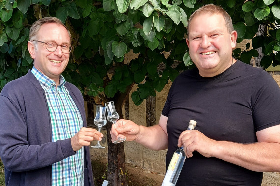 Niklas Hertwig und Michael Weber stoßen mit Edelbrand an