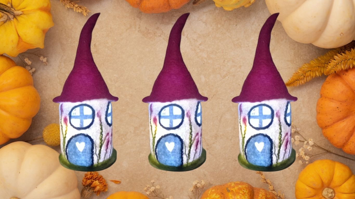 Drei Häuschen aus Filz mit rotem Hütchen, umrahmt von Kürbissen