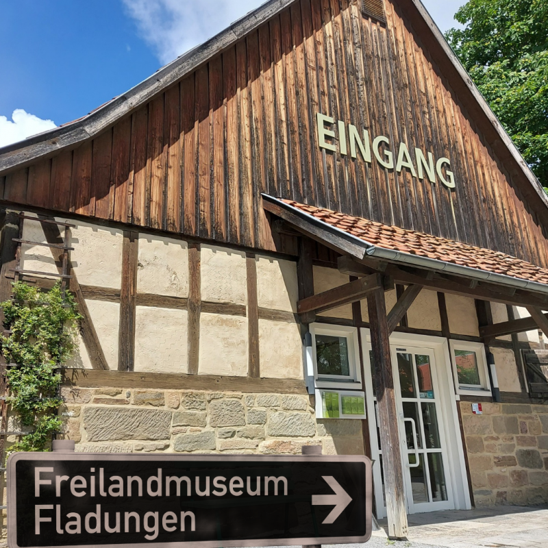 Museumseingang, davor Verkehrsschild mit Text: Freilandmuseum Fladungen und Pfeil nach rechts