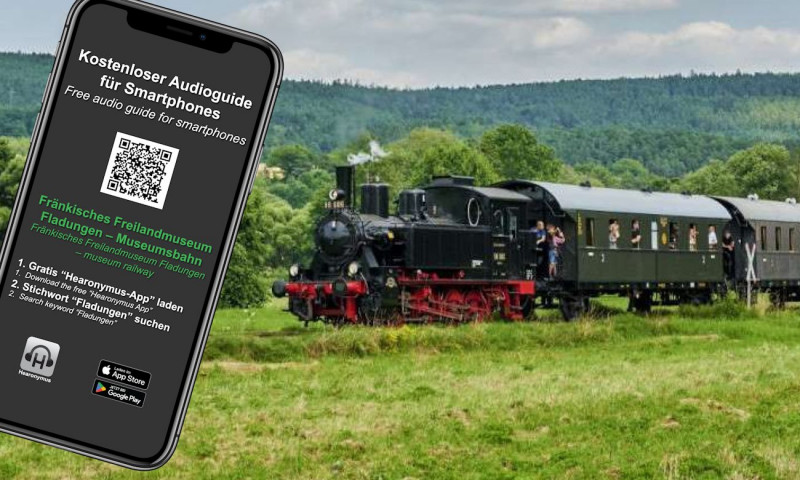 Abbildung eines Smartphones mit Anleitung zum Download Audioguide für Smartphones, im Hintergrund Dampfzug in grüner Landschaft