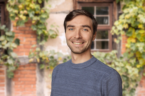 Adam Cerny, Mitarbeiter Hausforschung vor begr&uuml;nter Hausfassade