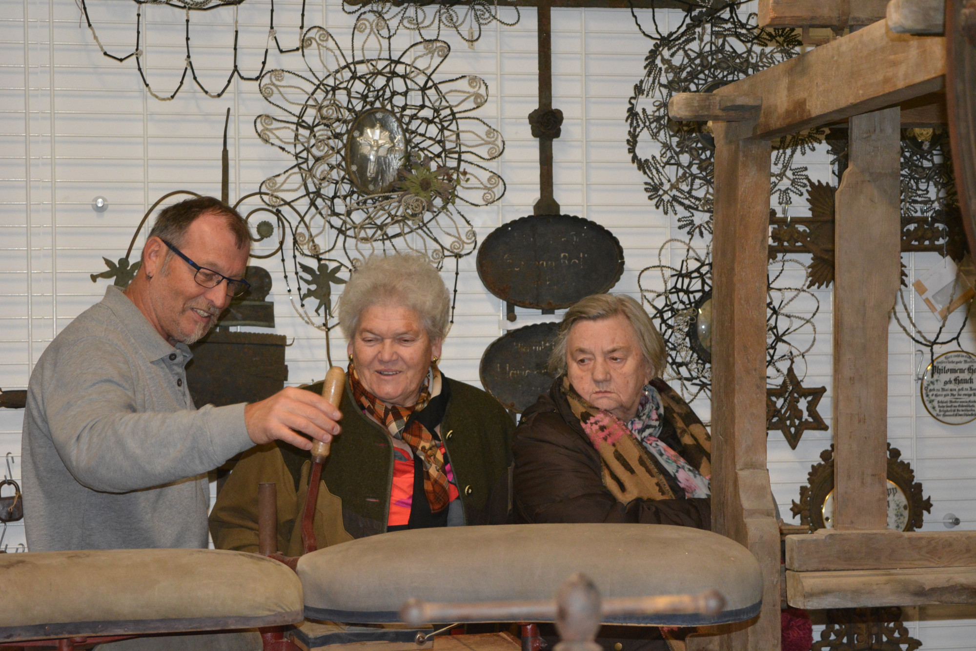 Drei Besucher sehen sich Objekte im Depot an