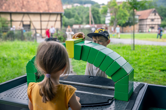 Zwei Kinder an einer Mitmachstation im Museumsgel&auml;nde
