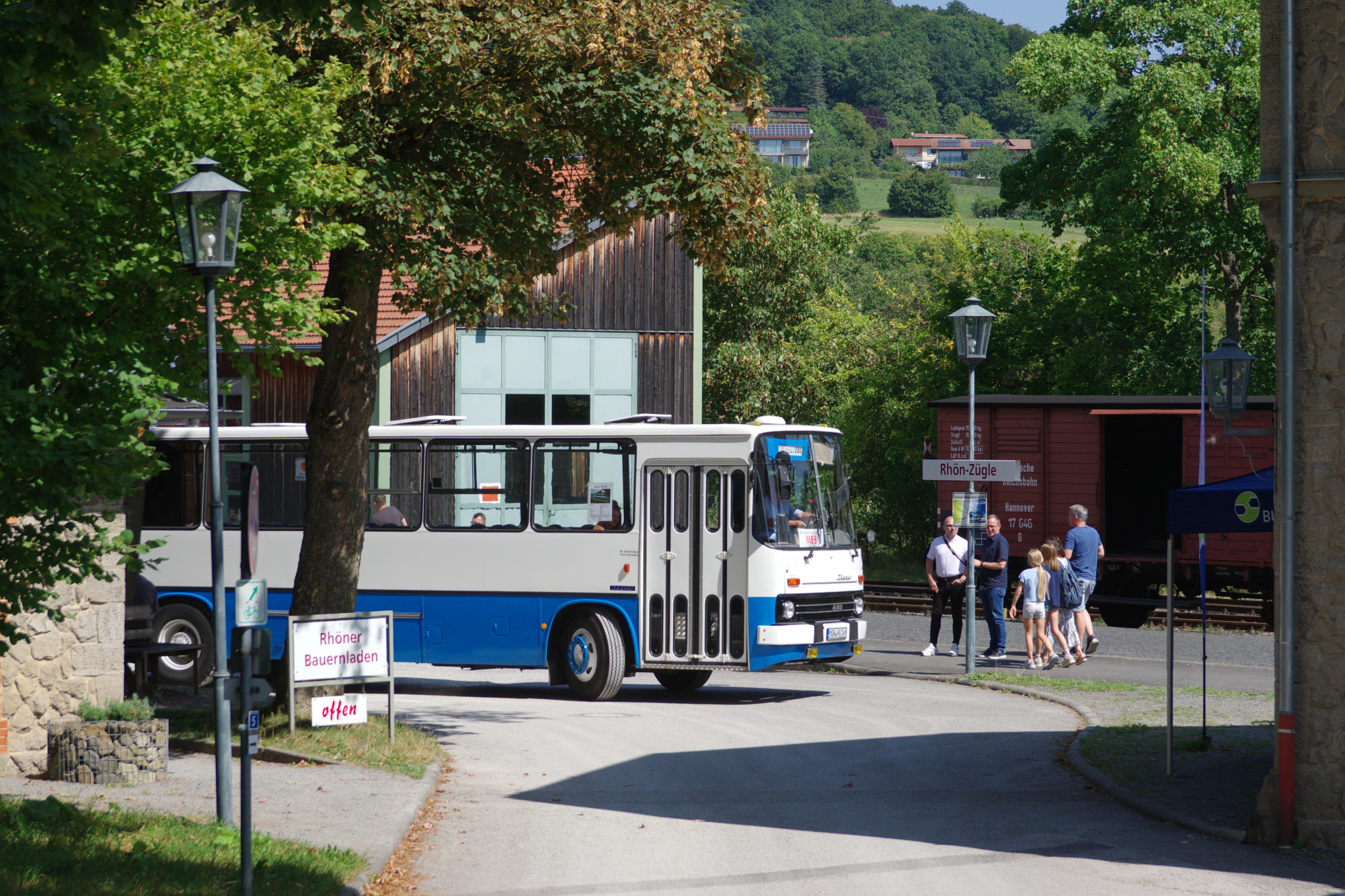 historischer blau-wei&szlig;er Bus biegt um die Ecke einer Stra&szlig;e