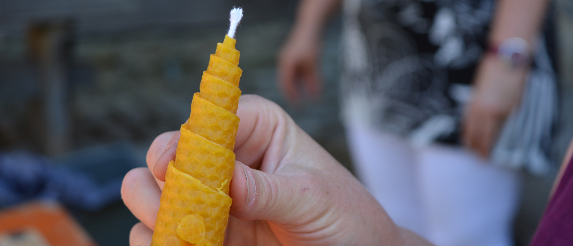 Gelbe Bienenwachskerze in H&auml;nden